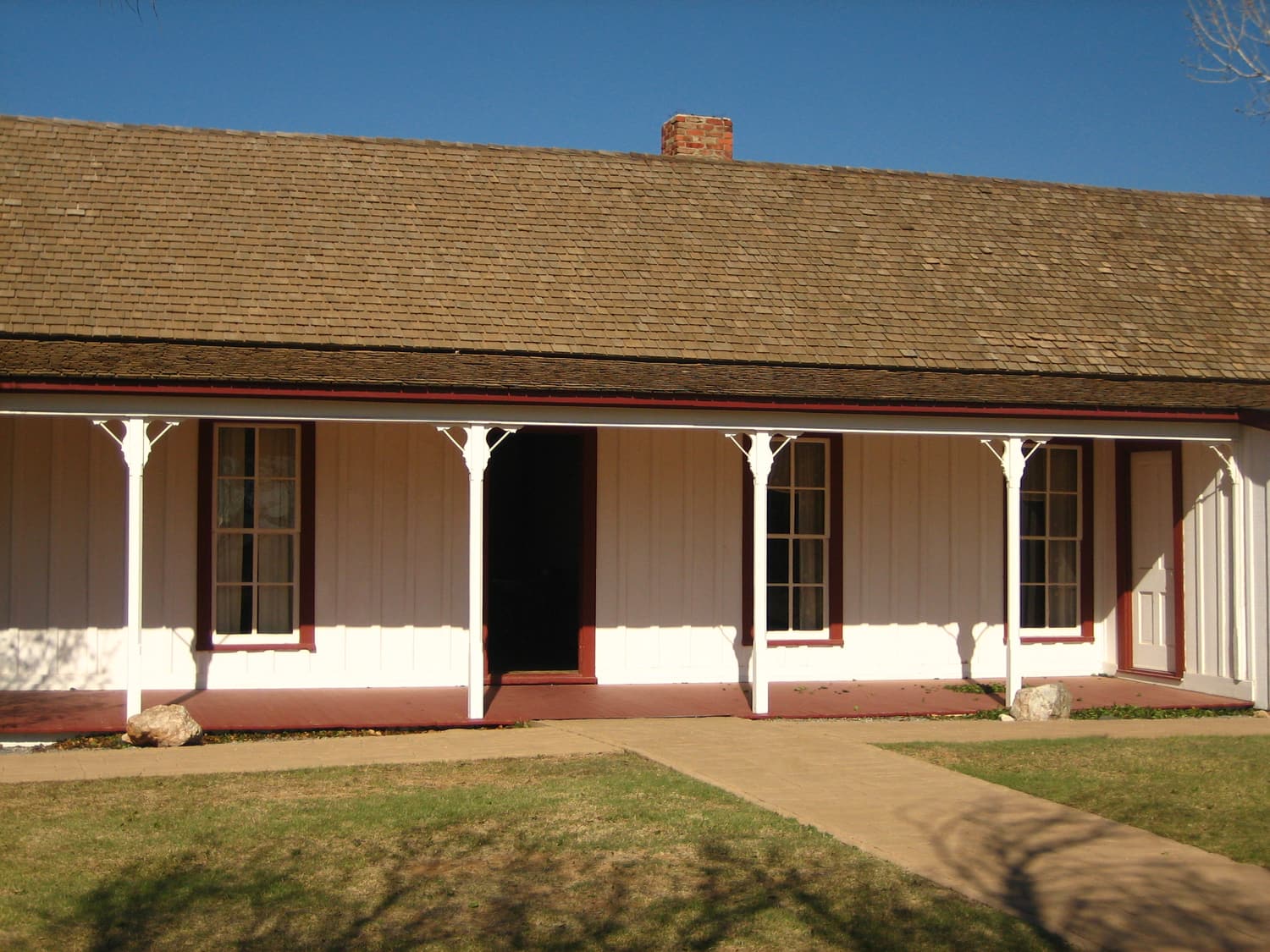 Ein weißes historisches Ranchhaus mit langer Veranda im National Ranching Heritage Center