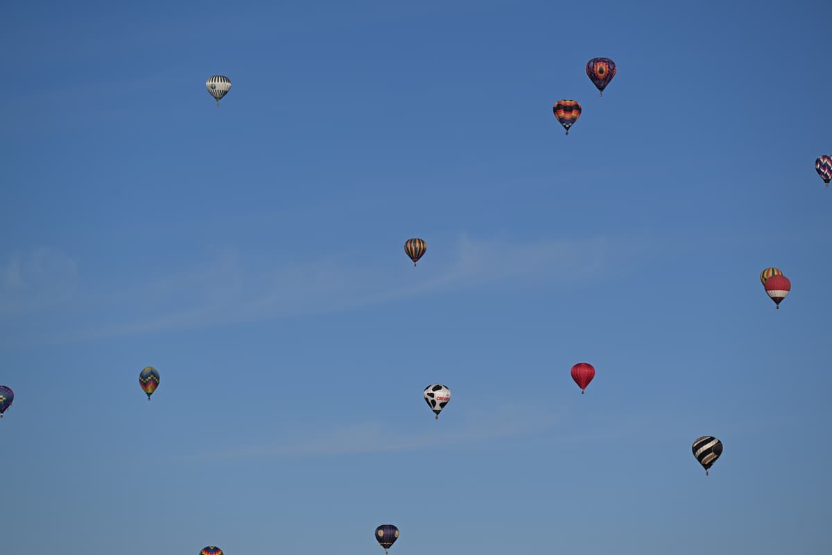 Dutzende Heißluftballone schweben am blauen Morgenhimmel über Albuquerque
